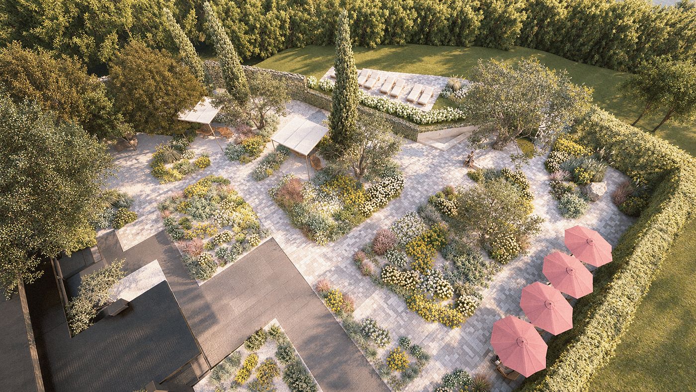 Vista dall'alto di un giardino secco: aiuole di piante xerofile, percorsi in pietra, ulivi e cipressi